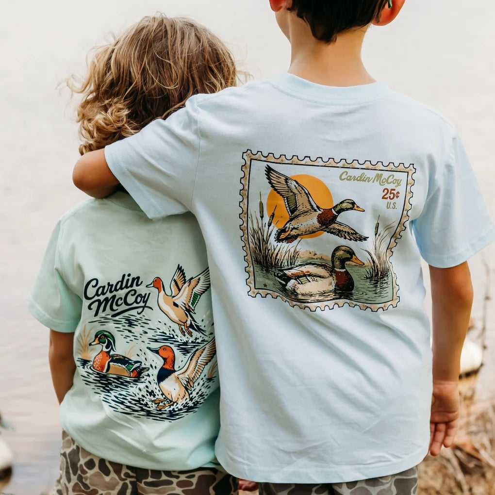 Two children wearing Cardin McCoy waterfowl and duck stamp tees.